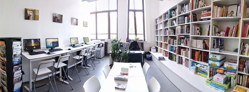 Photo intérieure de la bibliothèque de Jonfosse, avec table, livres et PC à disposition